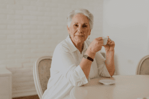 Charming elderly lady drinks coffee at home